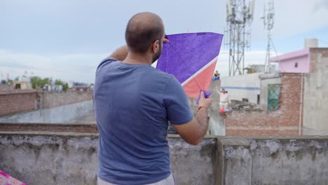 hombre indio inspeccionando cometa antes de volar