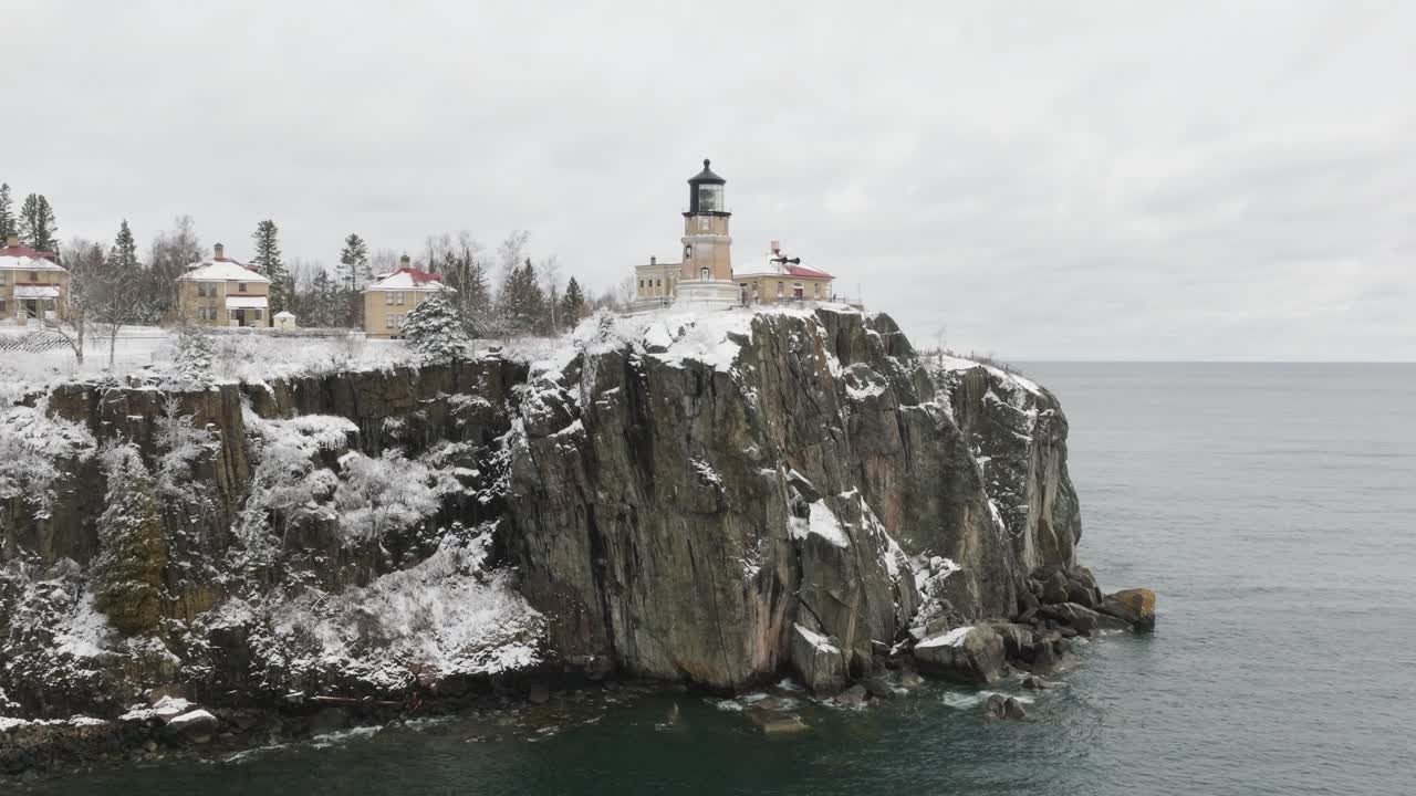 Split Rock Lighthouse And Keepers Home On The Rocky Cliff In Winter At Minnesota, USA. - aerial shot