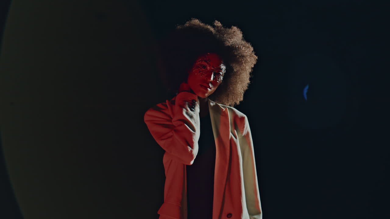 Elegant lady turning camera posing in light. Fashion model silhouette in dark