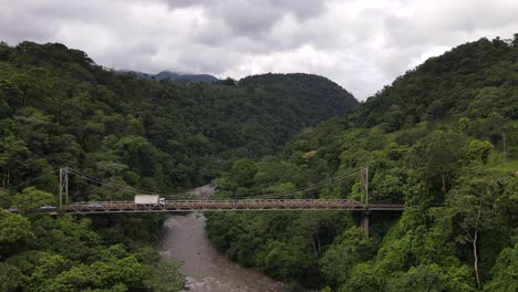 dron acercándose lentamente a un puente de acero en ruinas rodeado de una espesa selva tropical en medio de la nada