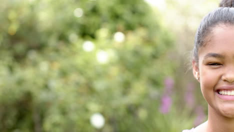 half portrait of happy african american girl smiling in sunny garden, copy space, slow motion