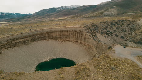 Captivating-aerial-view-with-a-drone-of-Pozo-de-las-Ánimas-in-Mendoza,-showcasing-the-surreal-beauty-of-this-natural-landmark-and-its-surrounding-landscapes