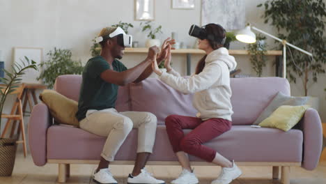 cheerful multiethnic couple using vr headsets at home