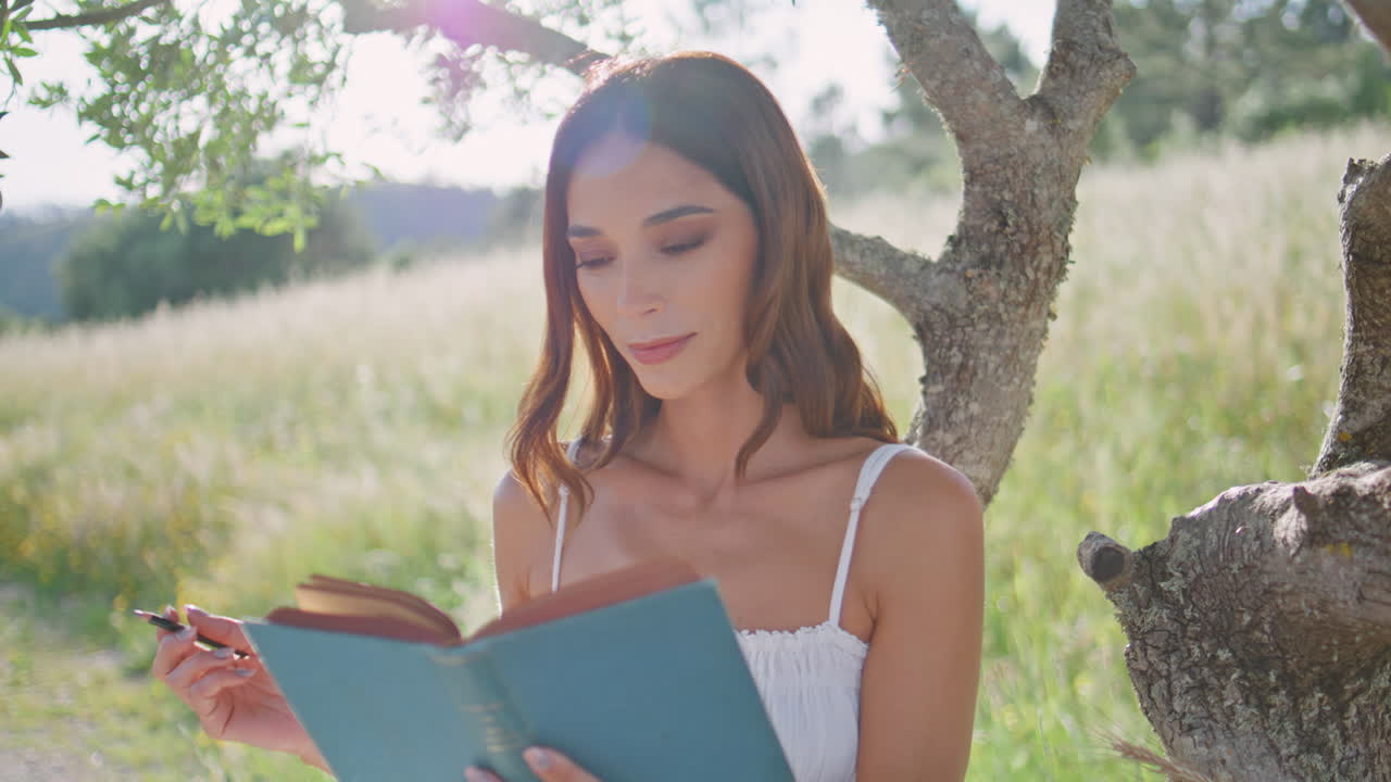 Closeup woman writing diary relaxing picnic closeup. Lady putting marks in book