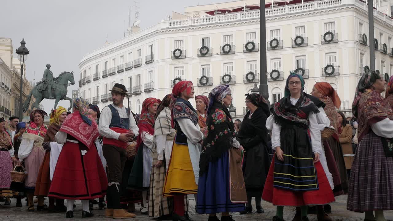 Traditional dressed women and men waiting for the spanish dance for trashumancia festival, Madrid, Spain, Plaza de Sol, static. Carlos III statue behind.