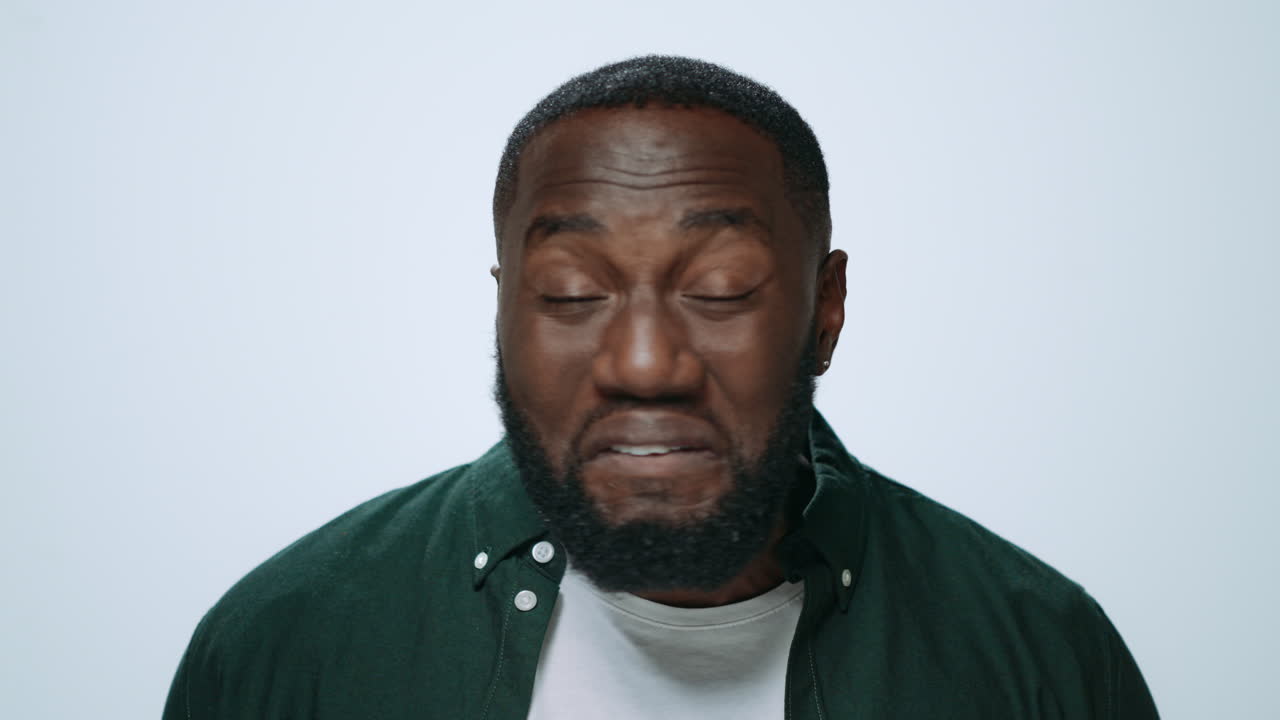Portrait of emotional african man posing with face expression in studio.