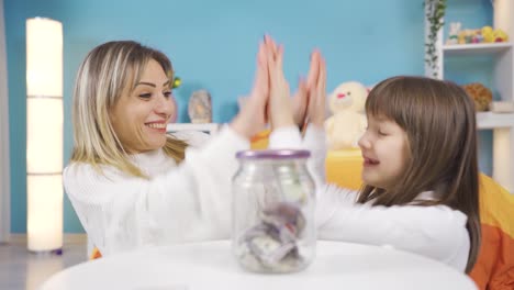little girl saves money in piggy bank for her dreams. frugal spending.