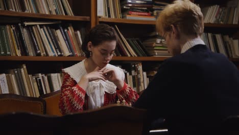 jugadores de ajedrez en una biblioteca