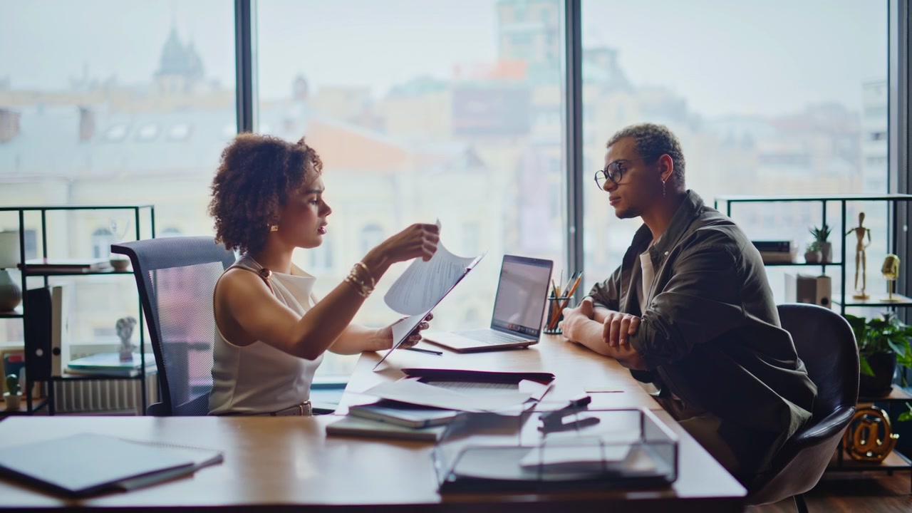 Business man and woman discussing paperwork office meeting reviewing documents