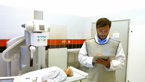 médico masculino usando una tableta digital en la sala de rayos x