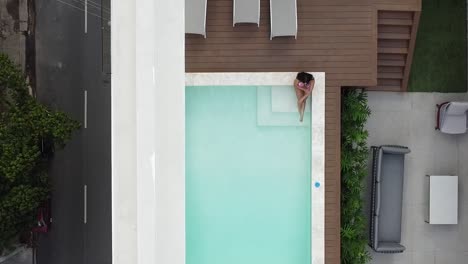 Drone-Vista-Chica-En-Bikini-Disfrutando-De-La-Piscina