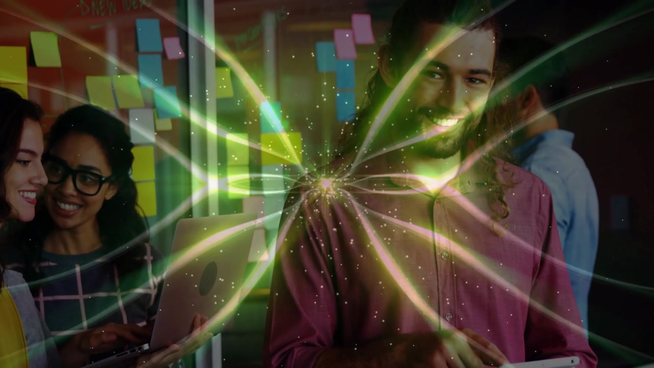 Man tapping tablet in tech office sending glowing data burst animating sticky notes for teamwork