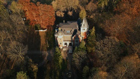 historic ghica castle during autumn in dofteana, romania. aerial pullback, tilt-up shot