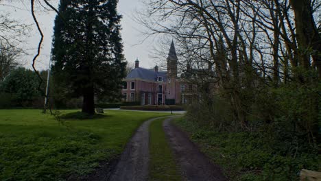 slow cinematic walkthrough scenery of european traditional authentic dutch mansion estate house castle with park, nature, trees and sunlight by smooth slow walking on the path