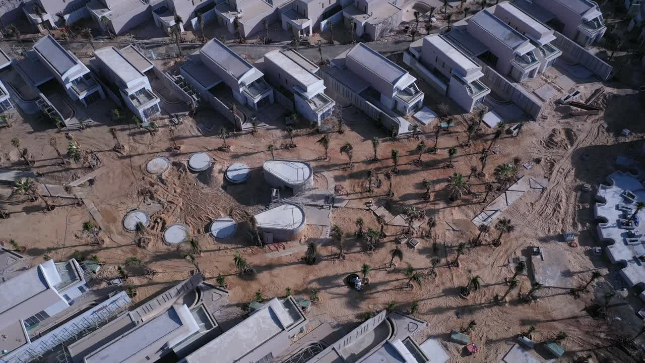 resort de playa o desarrollo residencial en construcción desde vista aérea que incluye villas, piscina y playa en un día soleado