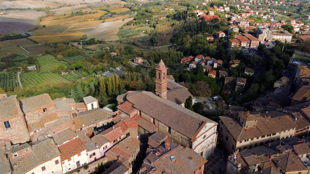 Aerial of Montepulciano Tuscany hilltop town with red roofs and rolling countryside landscape, pullback reveal