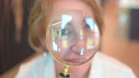 woman looking through a magnifying glass