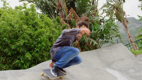 Front-view-of-young-caucasian-man-practicing-skateboarding-trick-on-ramp-in-skateboard-park-4k