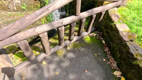 small waterfall near wooden bridge and greenery