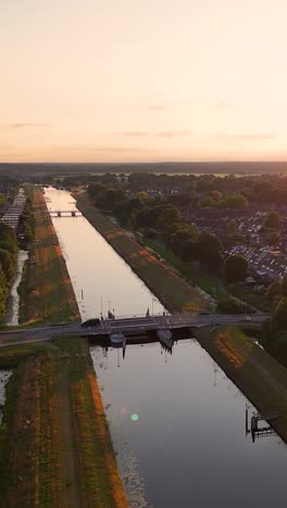 aerial view of a canal with bridge and residential area at sunset