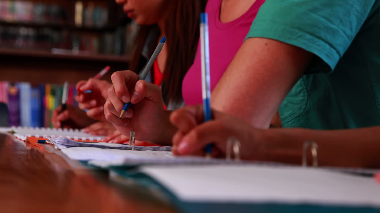 estudiantes escribiendo en la biblioteca