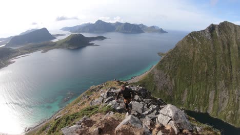 un joven con una chaqueta de camuflaje está subiendo los últimos escalones hasta la cima y la cima de la montaña mannen