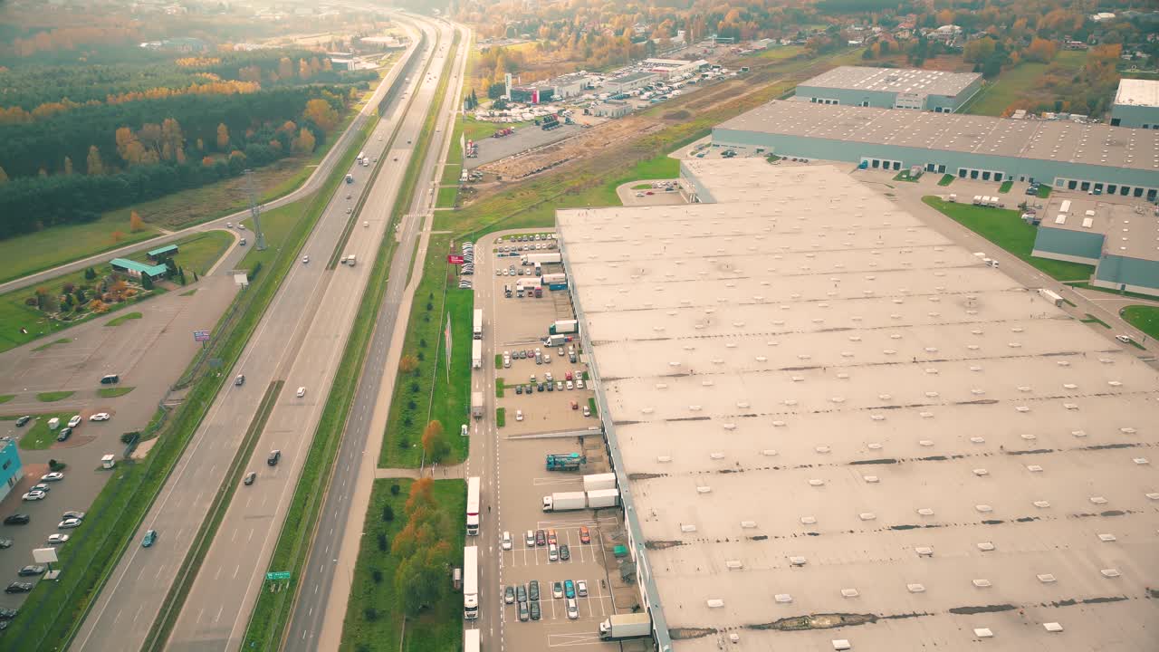 edificios del centro logístico, almacenes cerca de la autopista, vista desde la altura, un gran número de camiones en el estacionamiento cerca del almacén