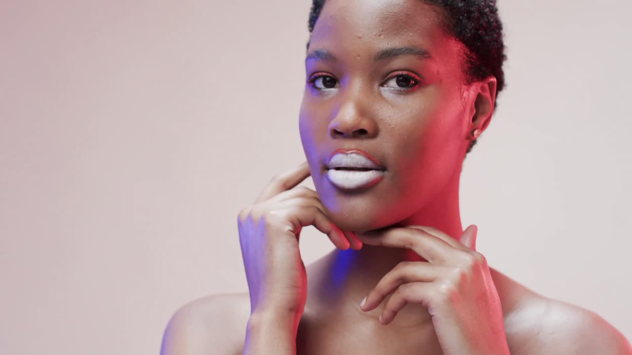 African american woman with short dark hair in blue and pink light with copy space, slow motion