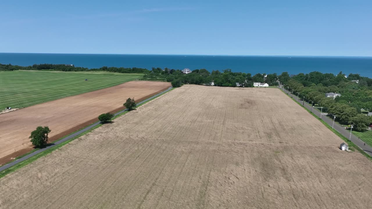 Drone flying at a low altitude over a farm with an ocean view