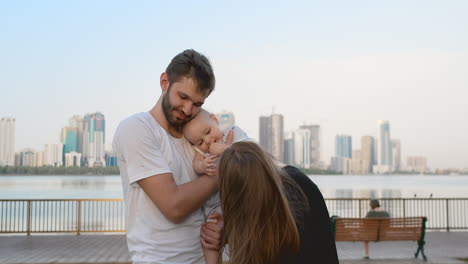 Mom-Dad-and-kid-laughing-and-hugging-enjoying-nature-outside.-Slow-motion.-The-boy-staggered.-4k