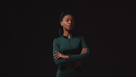 retrato de una atleta femenina decidida que lleva un traje de entrenamiento y se prepara psicológicamente para un evento deportivo contra un fondo de estudio negro 2