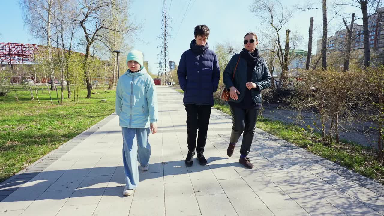 三人在城市公园人行道上同行