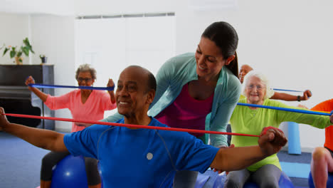 Vista-Frontal-De-Una-Entrenadora-Caucásica-Entrenando-A-Un-Hombre-Mayor-En-Ejercicio-En-El-Gimnasio-4k