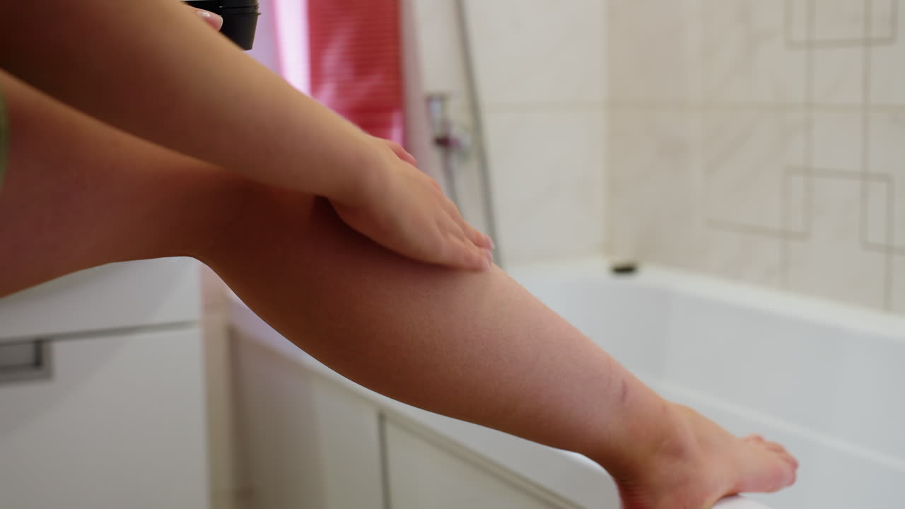 Close-up of leg view with hand applying cream, focusing on skin-care routine, moisturizing, after shower, wellness moment, personal care, smooth skin, rejuvenation, healthy lifestyle