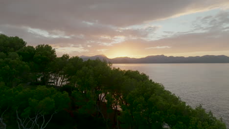 Drone-flight-on-the-coast-of-Mallorca-overlooking-the-area-of-Bahia-de-Pollenca-at-beautiful-sunset