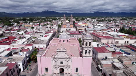 drone footage moving from the front of the jerez's parish to the sanctuary, showcasing bell towers and architecture