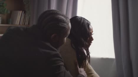 close up of couple at home sitting on sofa in lounge having break up argument 2