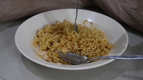 instant noodles are mixed with fork