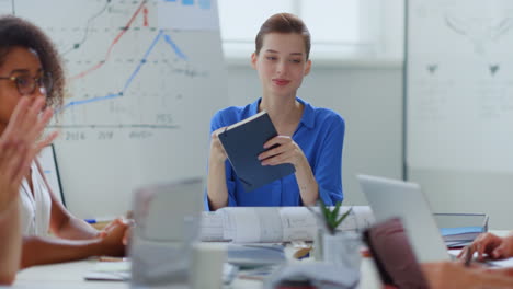 Jefa-Mirando-El-Diario-En-La-Sala-De-Reuniones.-Mujer-Planificando-El-Trabajo-Con-Colegas.