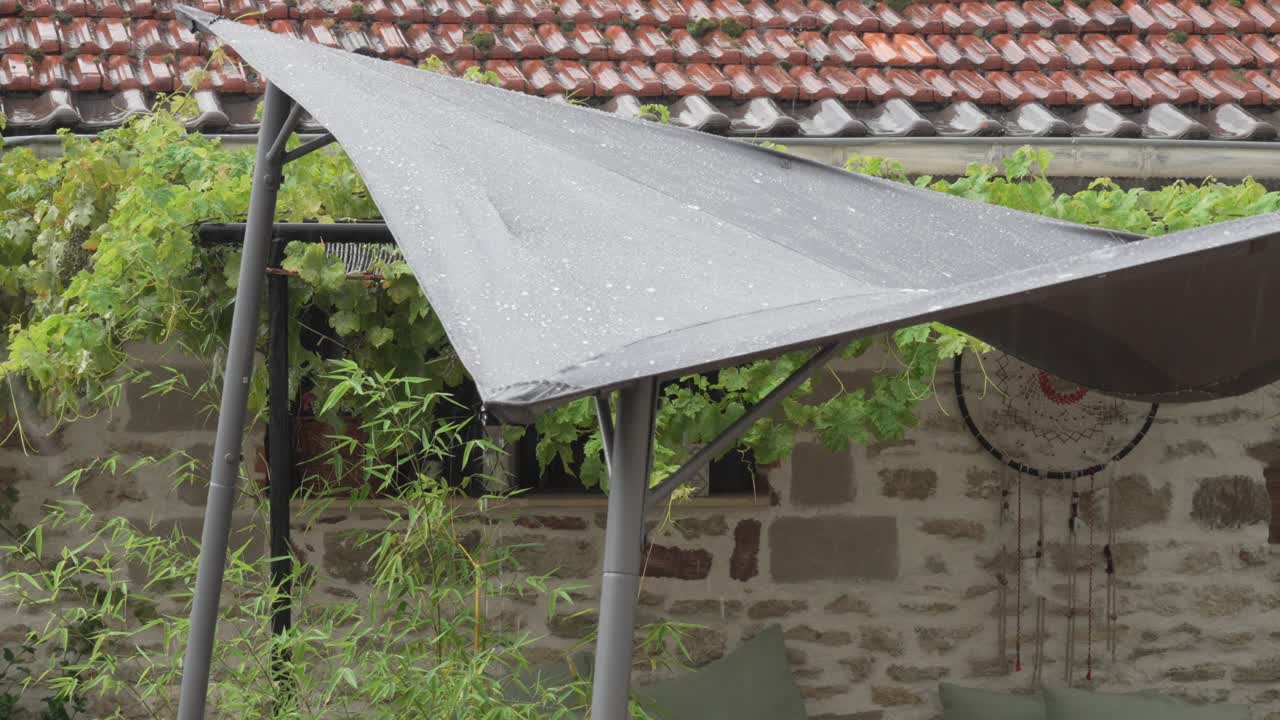 Rain falling on a patio with a sunshade