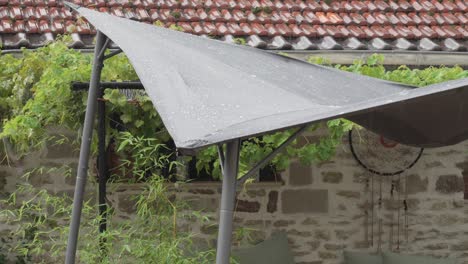 rain falling on a patio with a sunshade