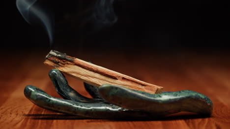 palo santo incense burning in ceramic hand