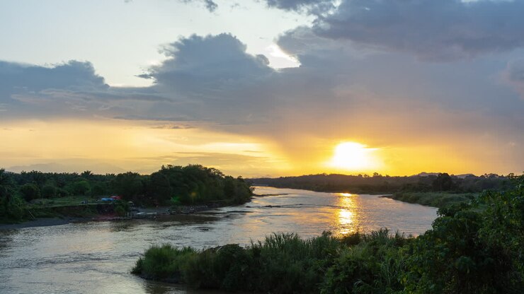 Golden Sunset over a Serene River Landscape with a Boat
