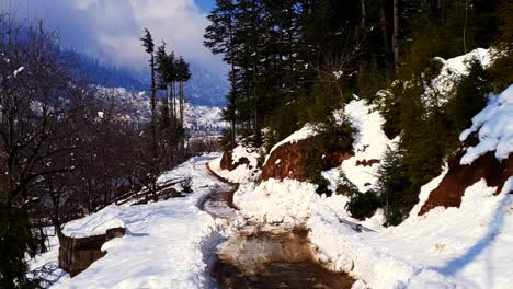 Person,-Die-Auf-Schnee-Läuft-Und-Traditionelle-Kaschmir-Kleidung-Trägt.-Frisches,-Weißes,-Winterlich-Verschneites-Kaschmir-Tal,-Straßen,-Häuser-Und-Das-Ganze-Tal-Scheinen-Aufgrund-Des-Schneefalls-Weiß