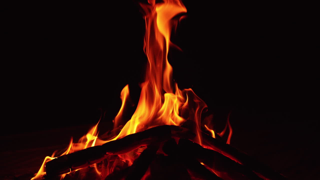 Gece yanan bir odun yığını. Karanlıkta yanan sıcak bir kamp ateşi.