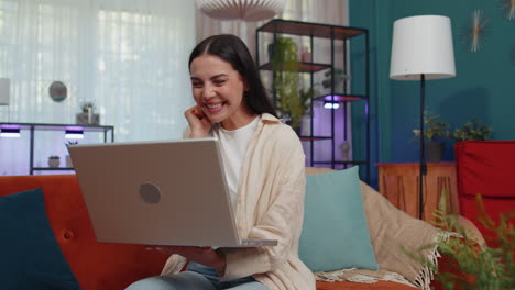 mujer joven asombrada usar computadora portátil, recibir un mensaje de buenas noticias, conmocionado por la victoria, celebrar la victoria