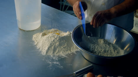 cocinero mezclando huevo y harina en la cocina 4k