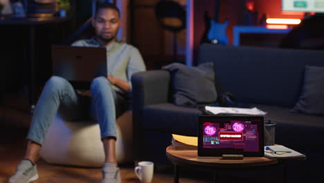 vertical video black it professional in loft working on cybersecurity with gadgets
