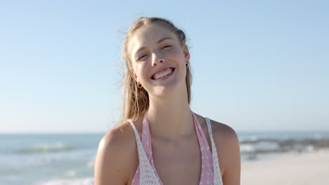 young caucasian woman smiles brightly at the beach