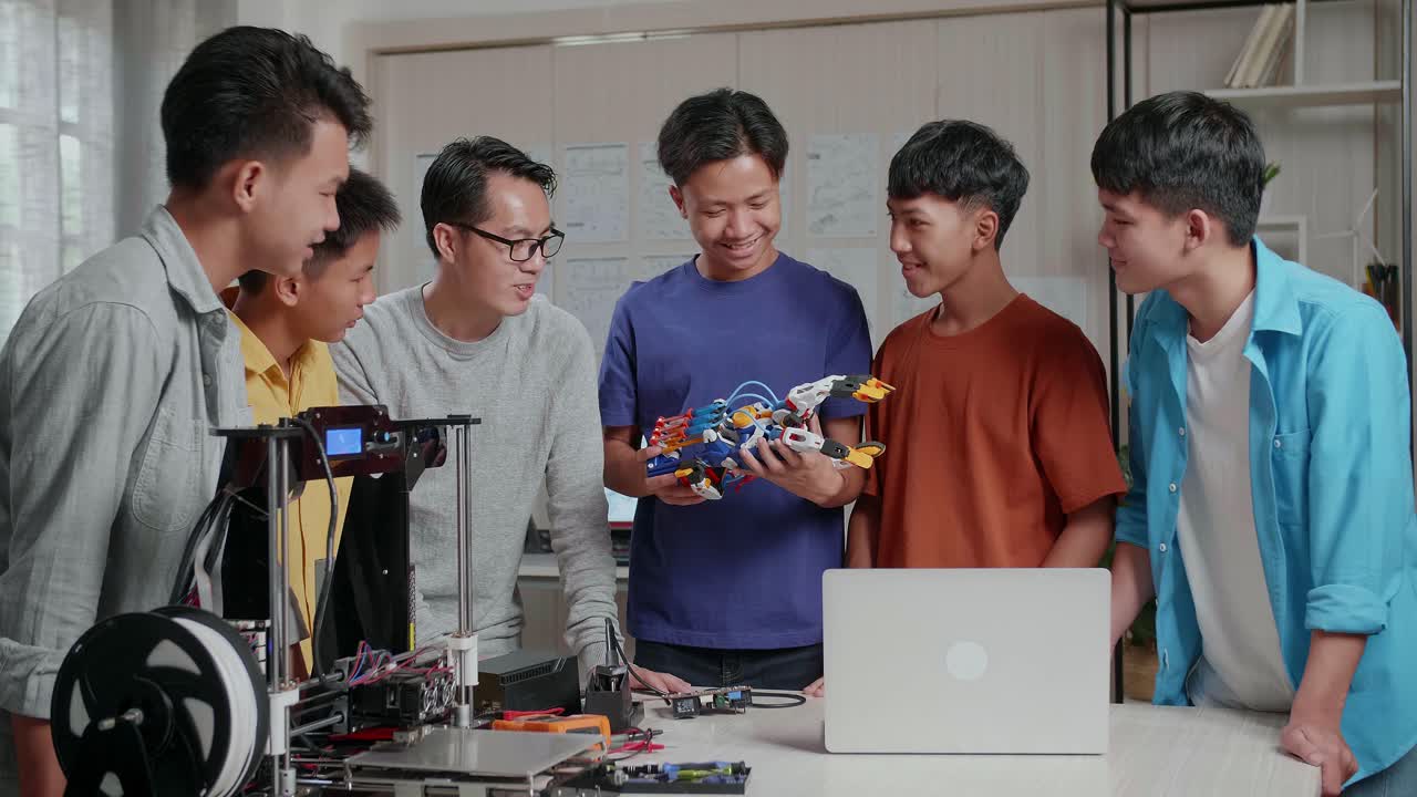 과 3d 프린팅을 가진 아시아 남자와 소년들이 학교에서 사이보그 손을 확인하고 있습니다.